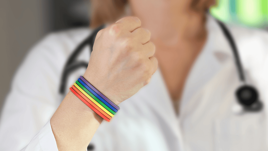 Clinician with stethoscope wears rainbow Pride bracelet 